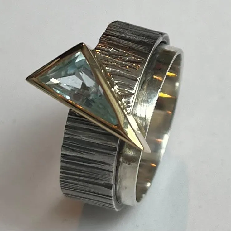 Anell d’argent texturat amb pedra blava triangular, joieria artesanal de Manuel Baró